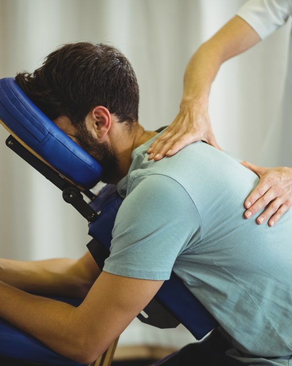 Physiotherapist giving back massage to a patient